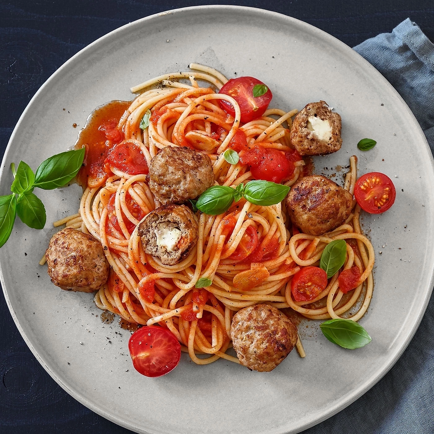 Spaghetti mit Fleischbällchen, Tomaten und Basilikum auf einem Teller