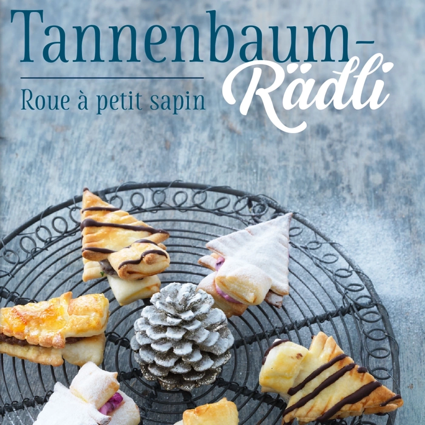 Weihnachtsplätzchen in Tannenbaumform auf einem Drahtgestell mit Tannenzapfen