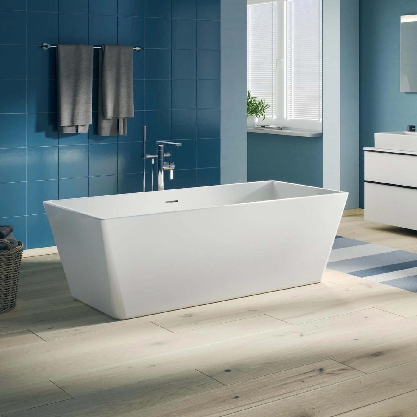 Ein modernes Badezimmer mit freistehender Badewanne, blauen Fliesen und Holzboden.