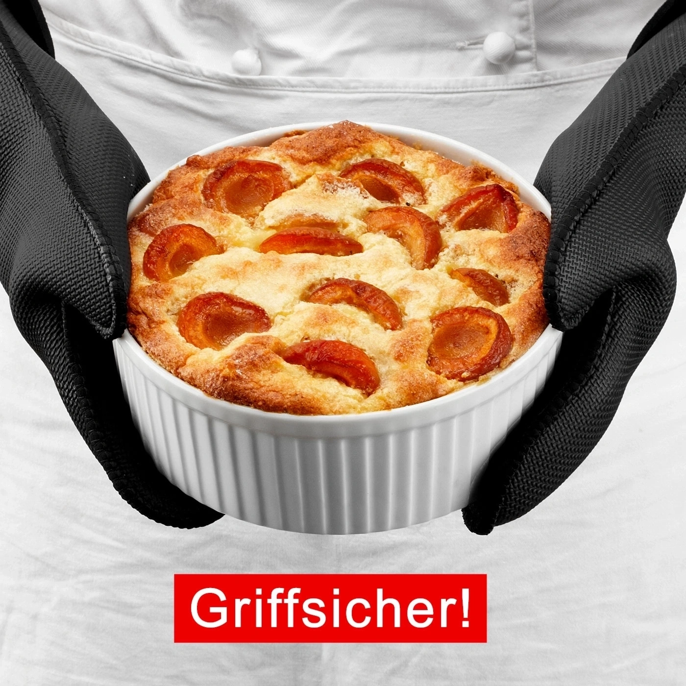 Person hält Auflauf in Ofenhandschuhen. Roter Schriftzug: Griffsicher!