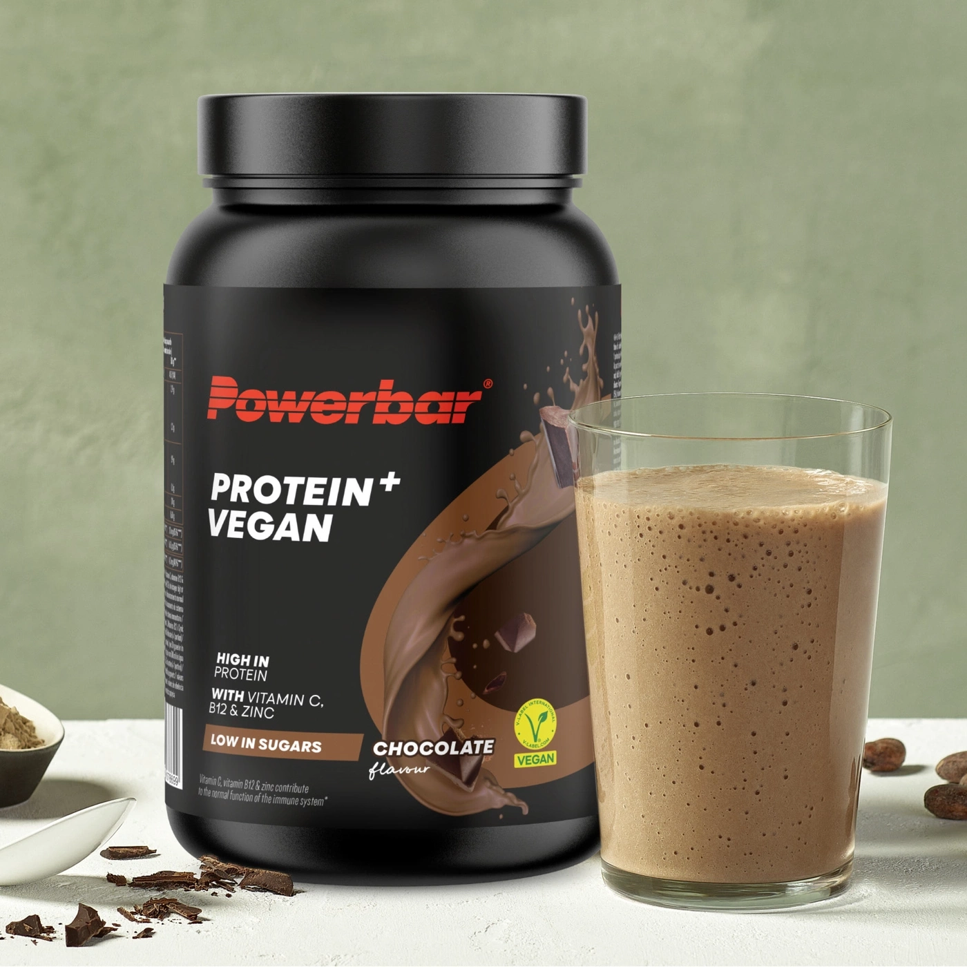 Schokoladen-Proteinshake mit einer Dose Powerbar und Kakaobohnen.