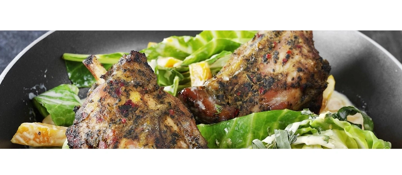 Gegrillte Lammkeule mit frischem grünen Salat und Orangenstücken