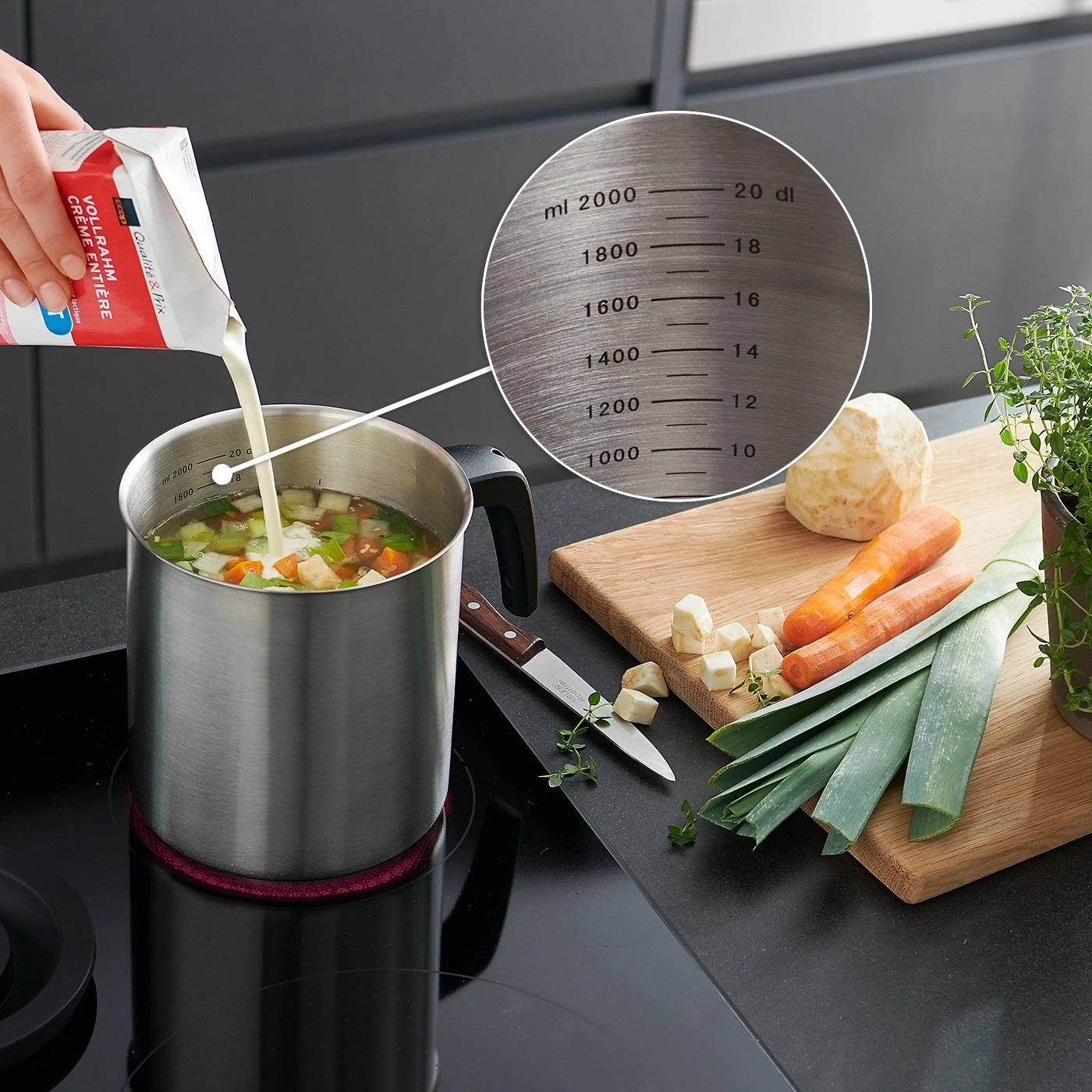 Kochen mit Sahne: Topf, Gemüse, Zutaten, Kochfeld, Messer, Holzbrett, Kräuter, Messbecher.