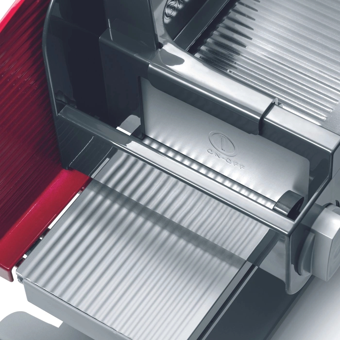 Nahaufnahme eines Fleischschneiders mit Ein- und Ausschalter und roter Komponente