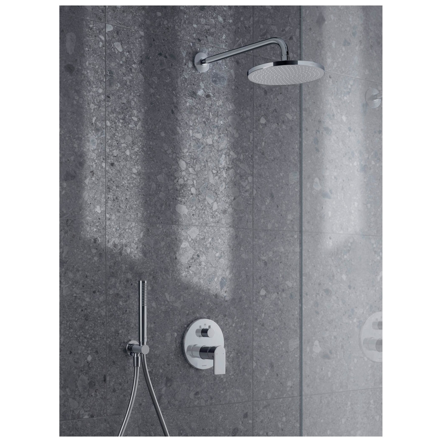 Duscharmatur mit Handbrause und Regler an grauer Wand mit Fliesen