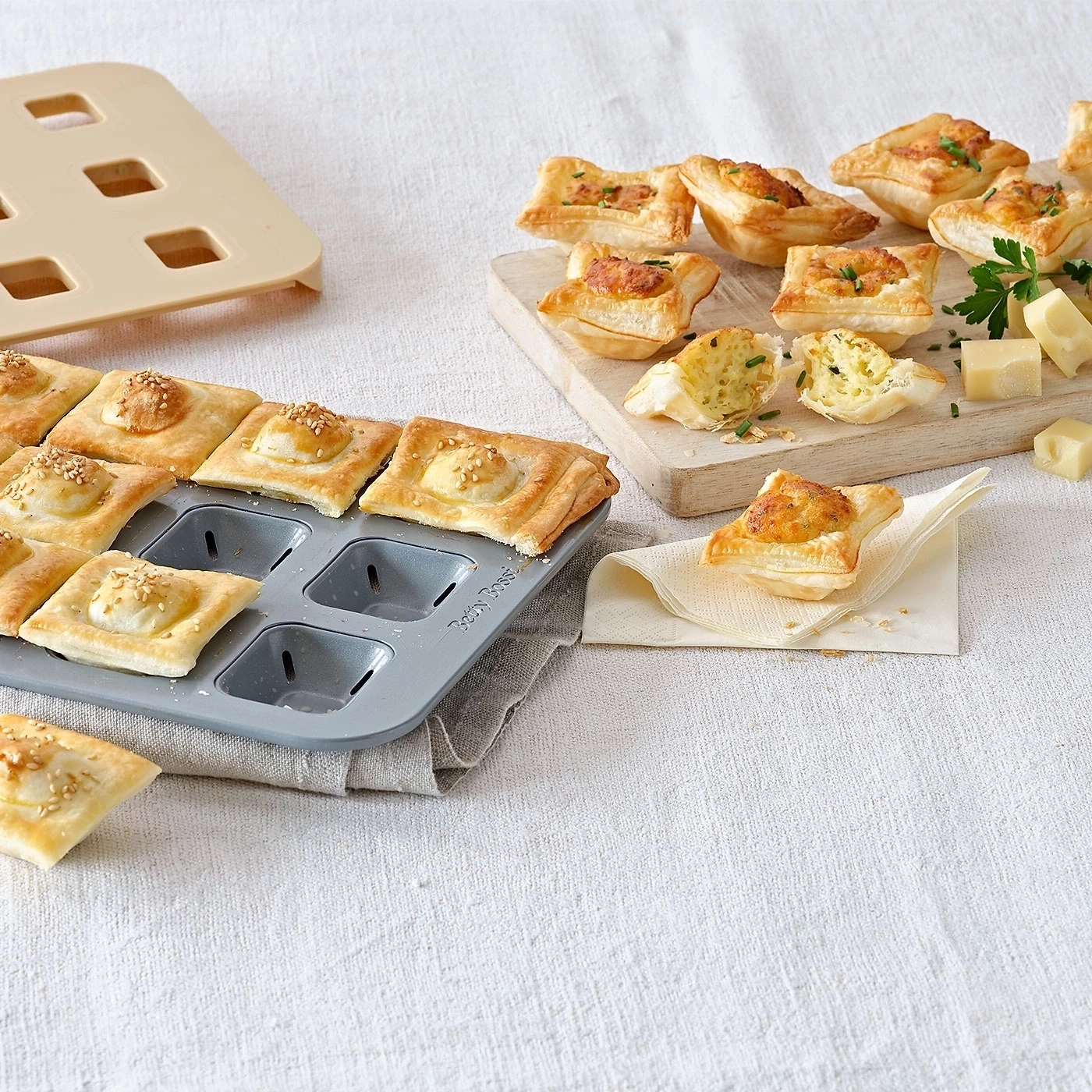 Köstliche, quadratische Gebäckstücke mit Käse auf einem Tisch serviert.