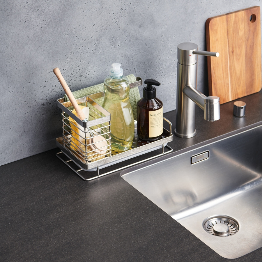 Küchenutensilien auf einer Arbeitsplatte neben einem Waschbecken und Wasserhahn