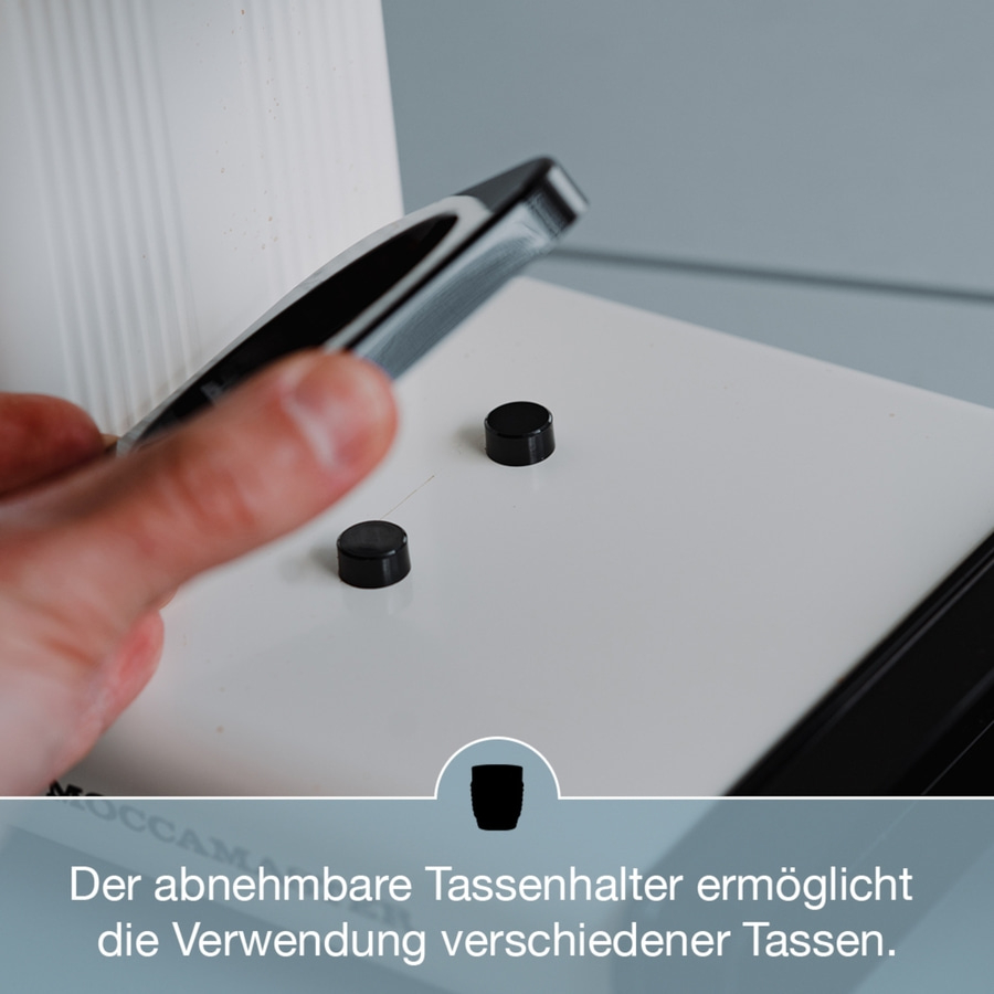 Abnehmbarer Tassenhalter mit schwarzen Knöpfen und Text darunter.