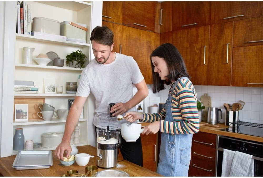 Mann und Frau kochen zusammen in der Küche, lächeln und haben Spaß.