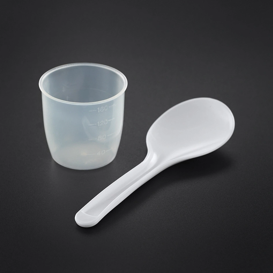 Messbecher und Löffel auf schwarzem Hintergrund, weißes Plastik