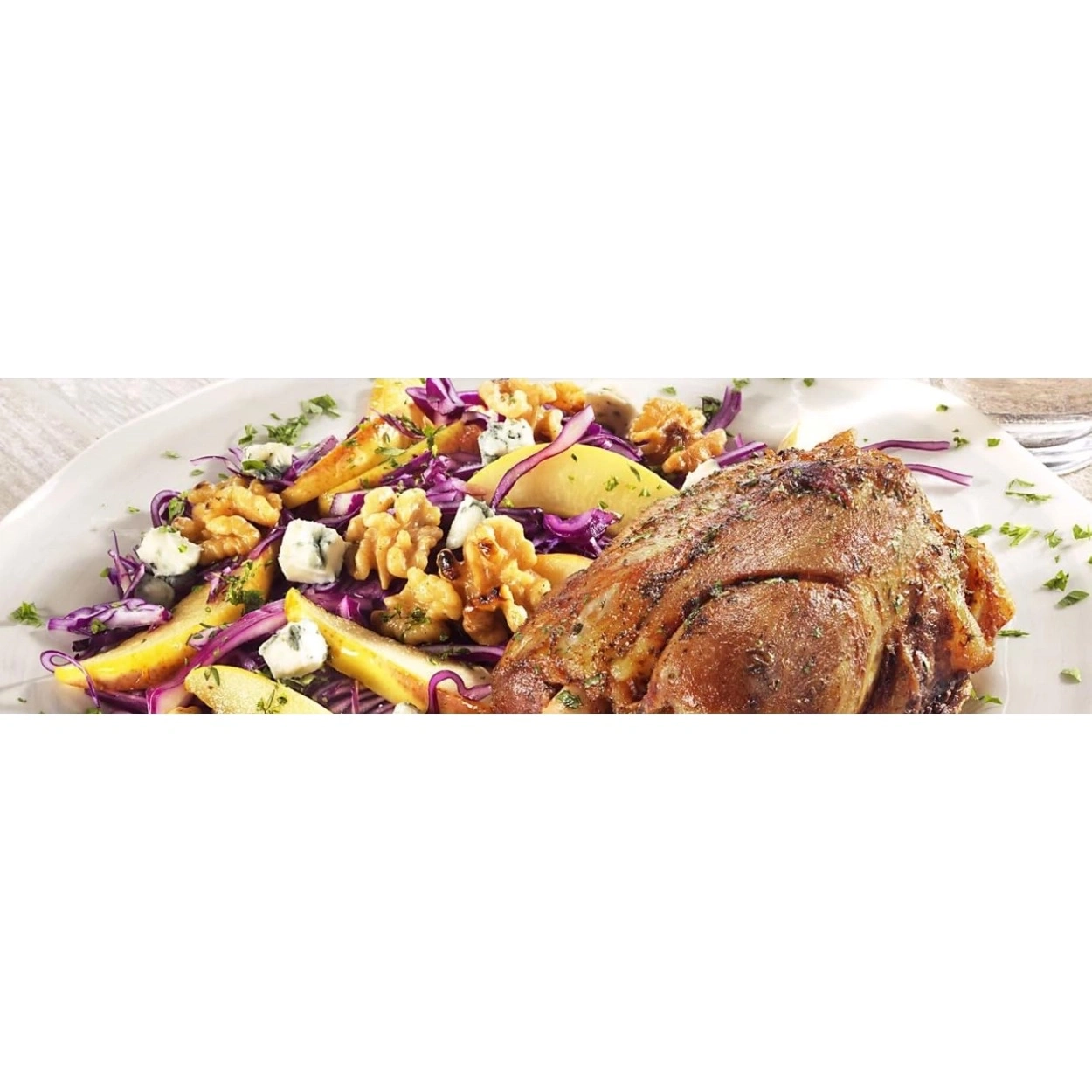 Ein gebratenes Fleischgericht mit Rotkohl-, Apfel- und Walnusssalat.