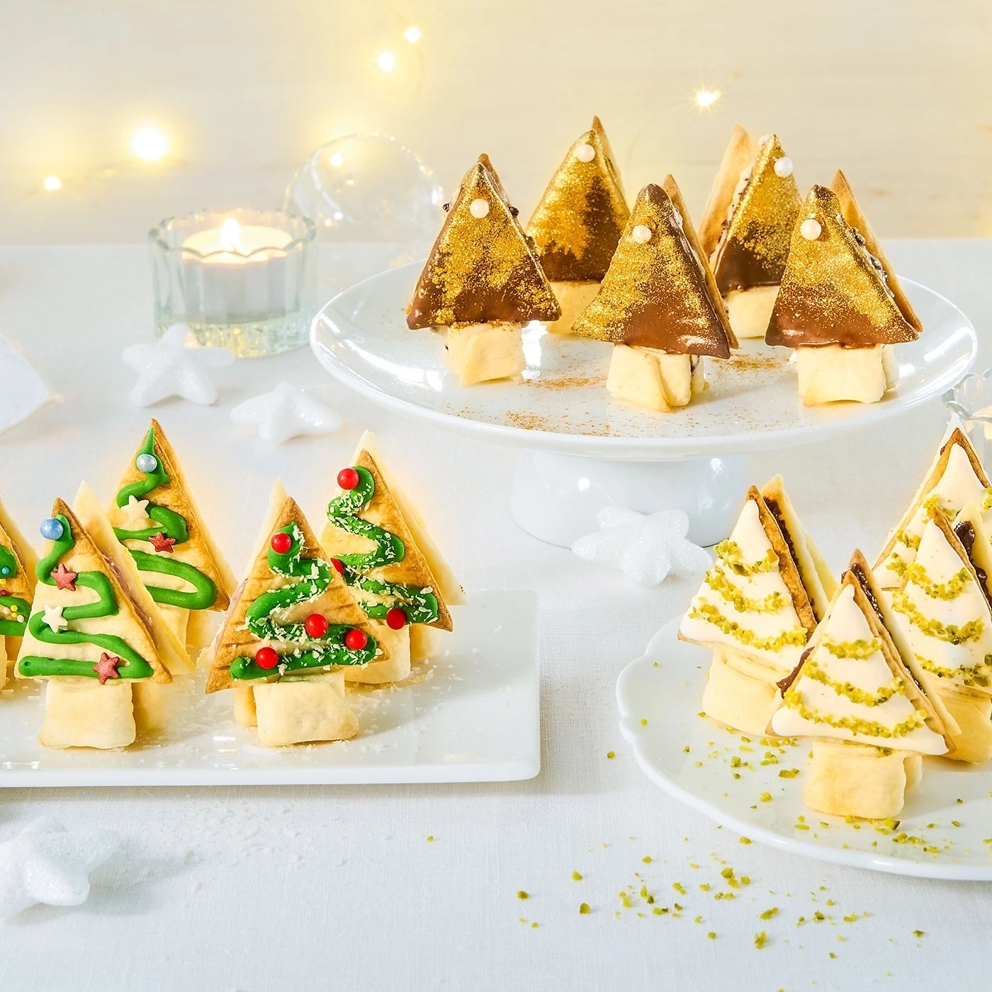Weihnachtliche Leckereien: Baumförmige Gebäckstücke auf Tellern und einem Kuchenständer.