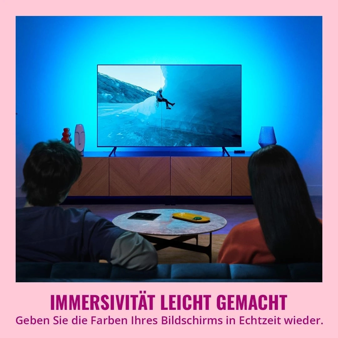 Ein Paar schaut einen Film, der von immersiven Lichtern beleuchtet wird.