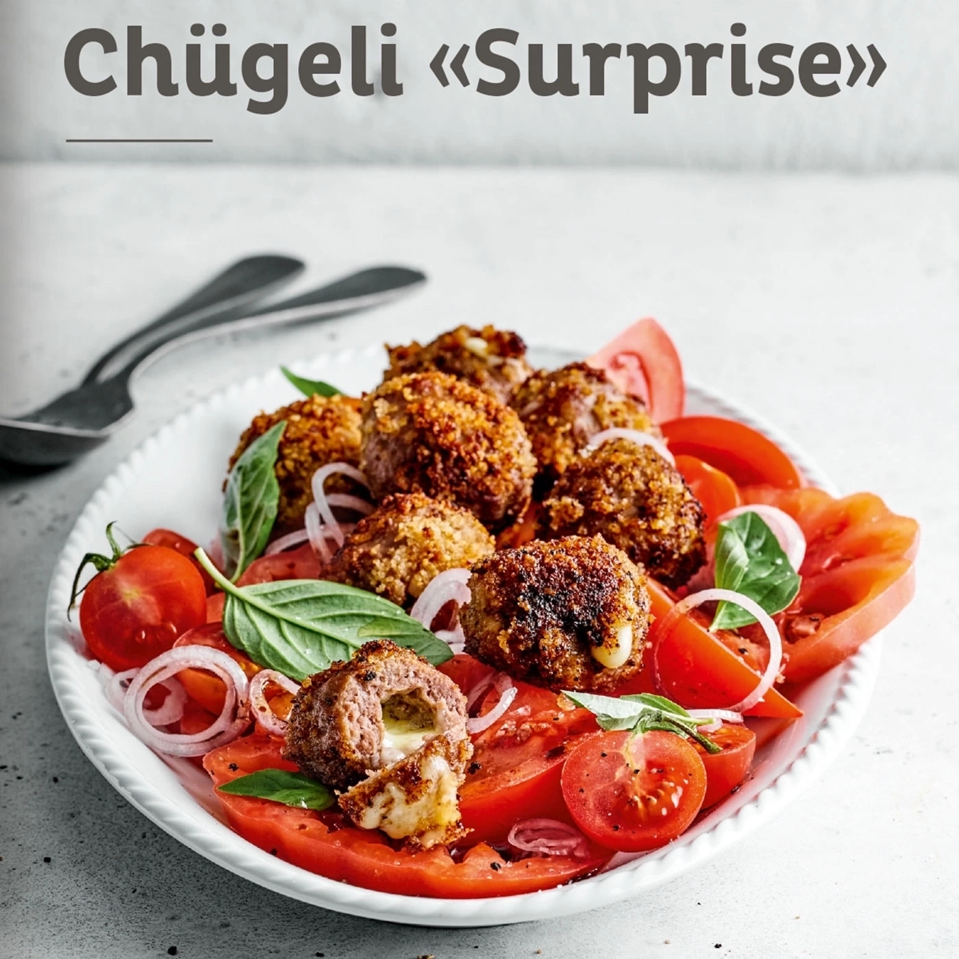 Chügeli «Surprise» mit Tomaten, Zwiebeln und Basilikum auf einem Teller