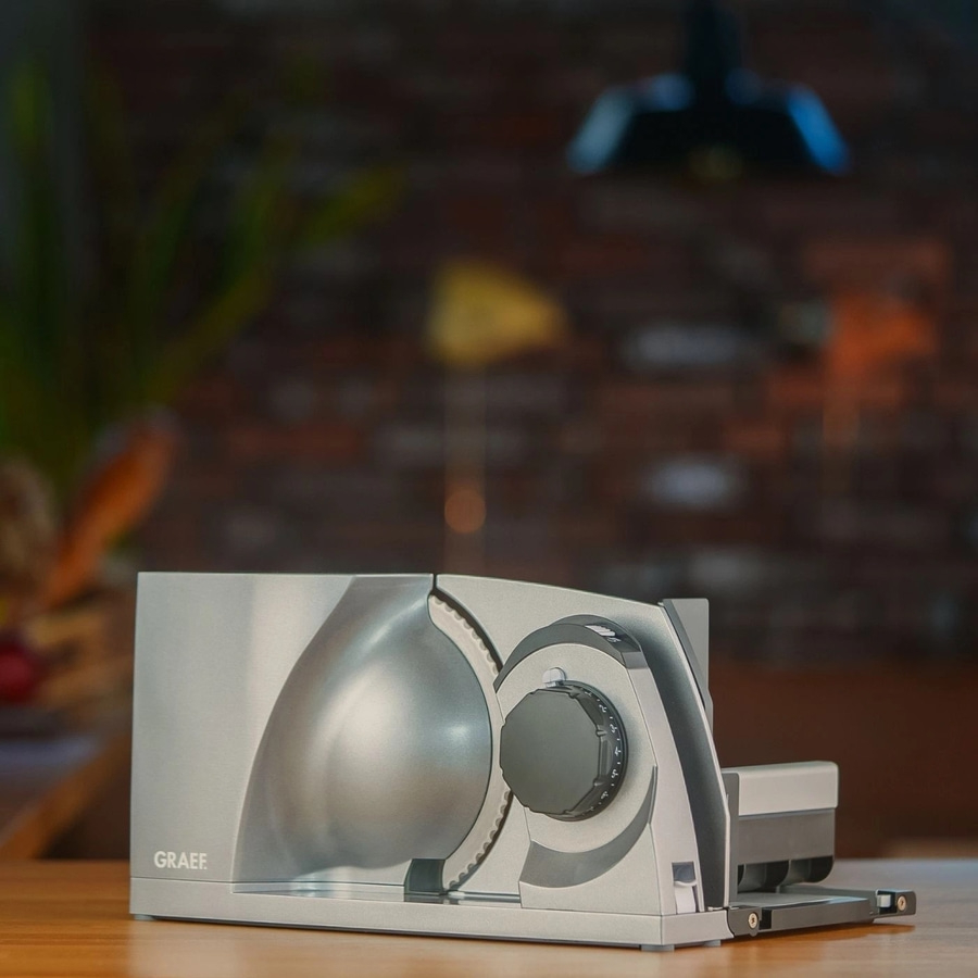 Graef Allesschneider auf einem Holztisch, Nahaufnahme, silberfarben