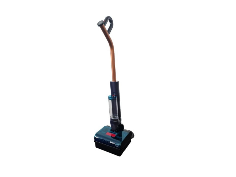 ein Dyson kabelloser Nass-/Trockensauger mit einem transparenten Behälter und einem Kupferrohr, der auf dem Boden steht.