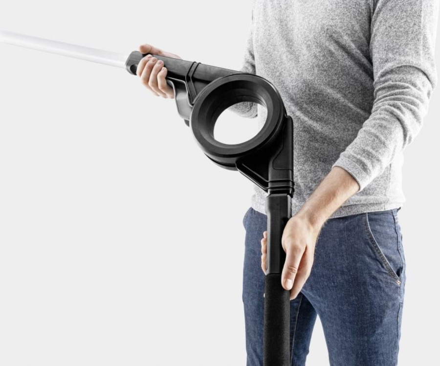 Mann hält schwarzes Gerät mit großem Ring und weißem Stab, Jeans