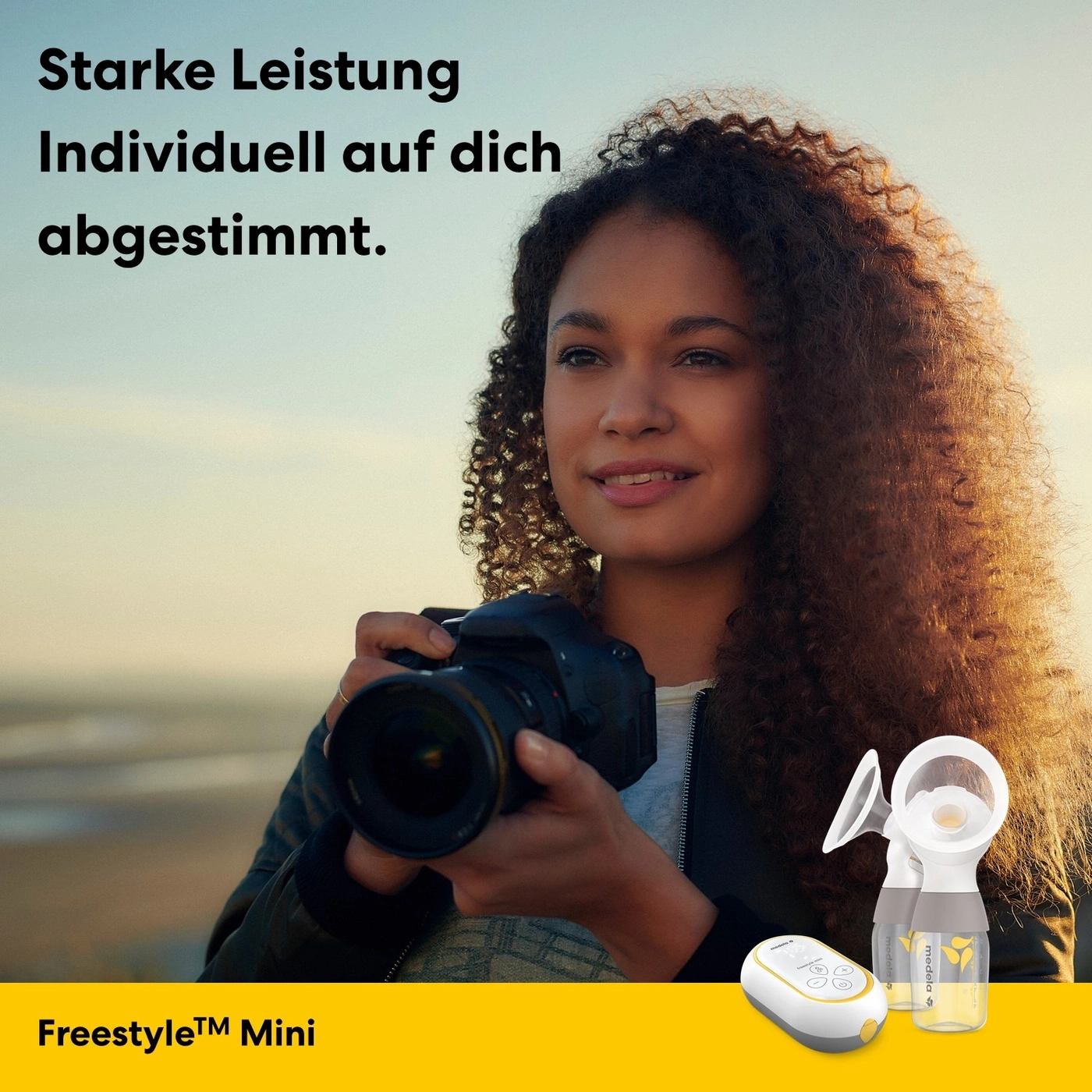Frau mit Kamera und Medela Freestyle Mini Milchpumpe.