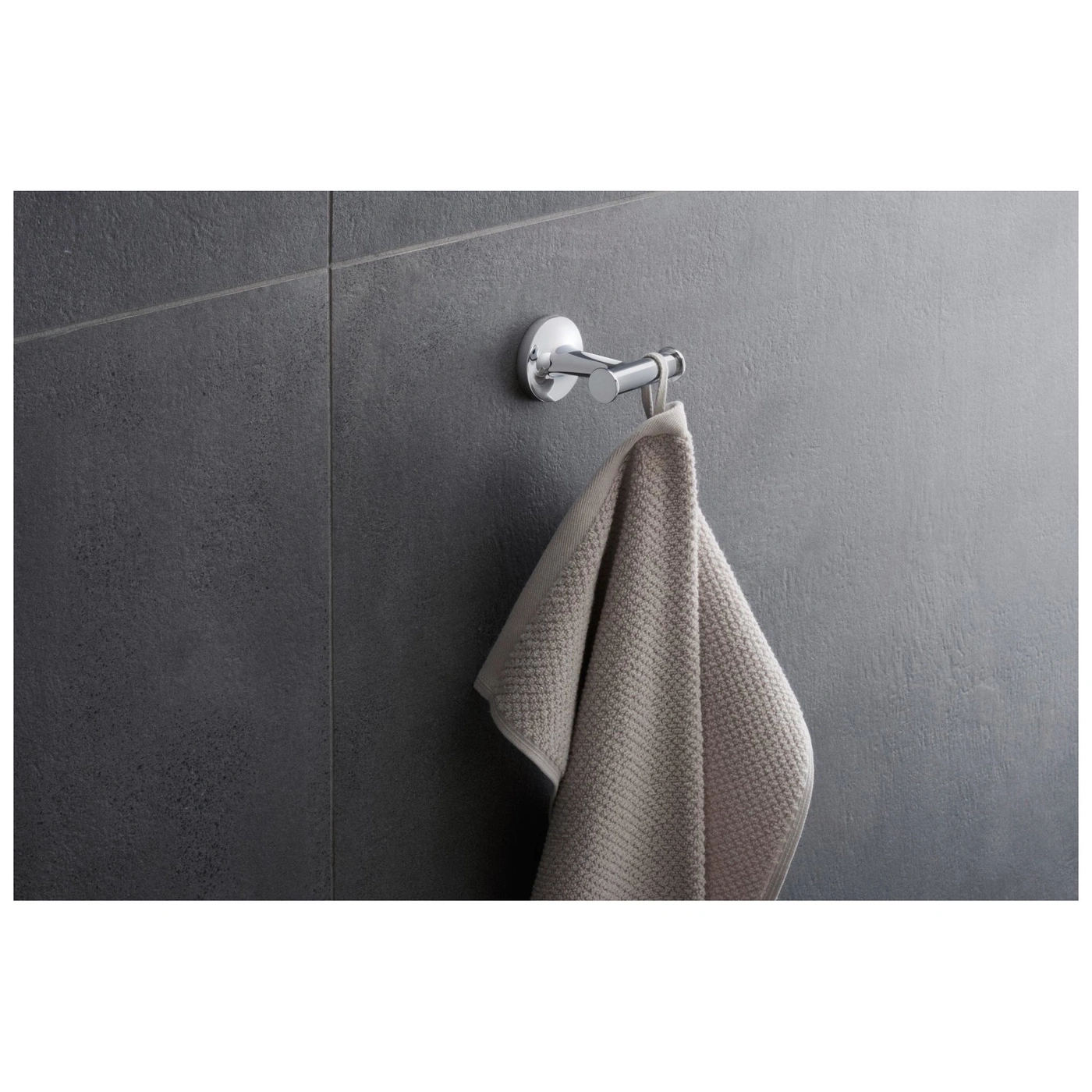 Handtuchhalter mit Handtuch an grauer Wand. Badezimmer-Dekoration.