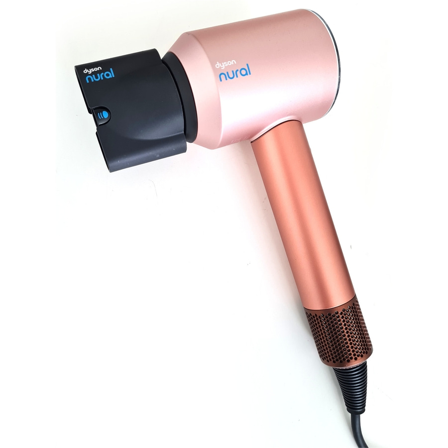 Ein roségoldener Haartrockner mit schwarzem Aufsatz