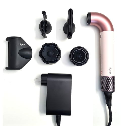 Dyson Haartrockner mit Zubehör auf weißem Hintergrund. Haartrockner, Aufsätze und Ladegerät.