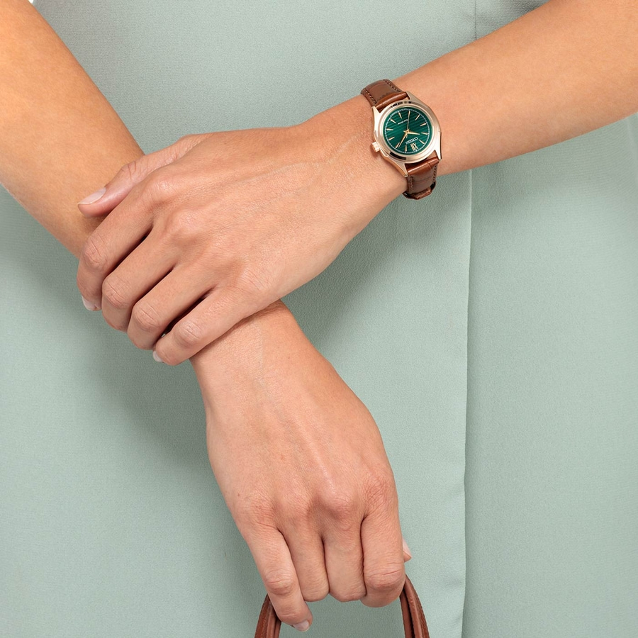 Nahaufnahme einer Person mit einer Uhr am Handgelenk und einem grünen Zifferblatt