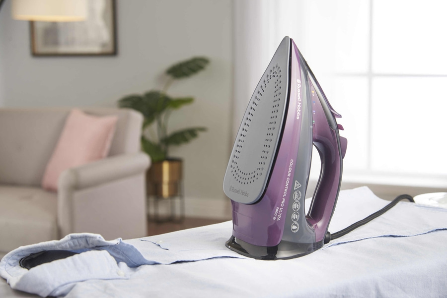 Bügelbrett mit Bügeleisen und Hemd. Russell Hobbs Bügeleisen, violett. Bügeln zu Hause.