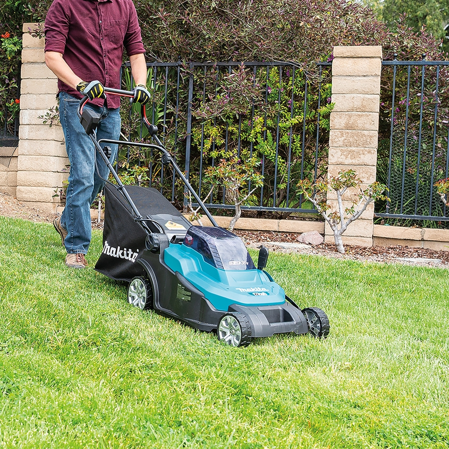 Mann mäht Rasen mit einem Rasenmäher im Garten, Makita-Marke.