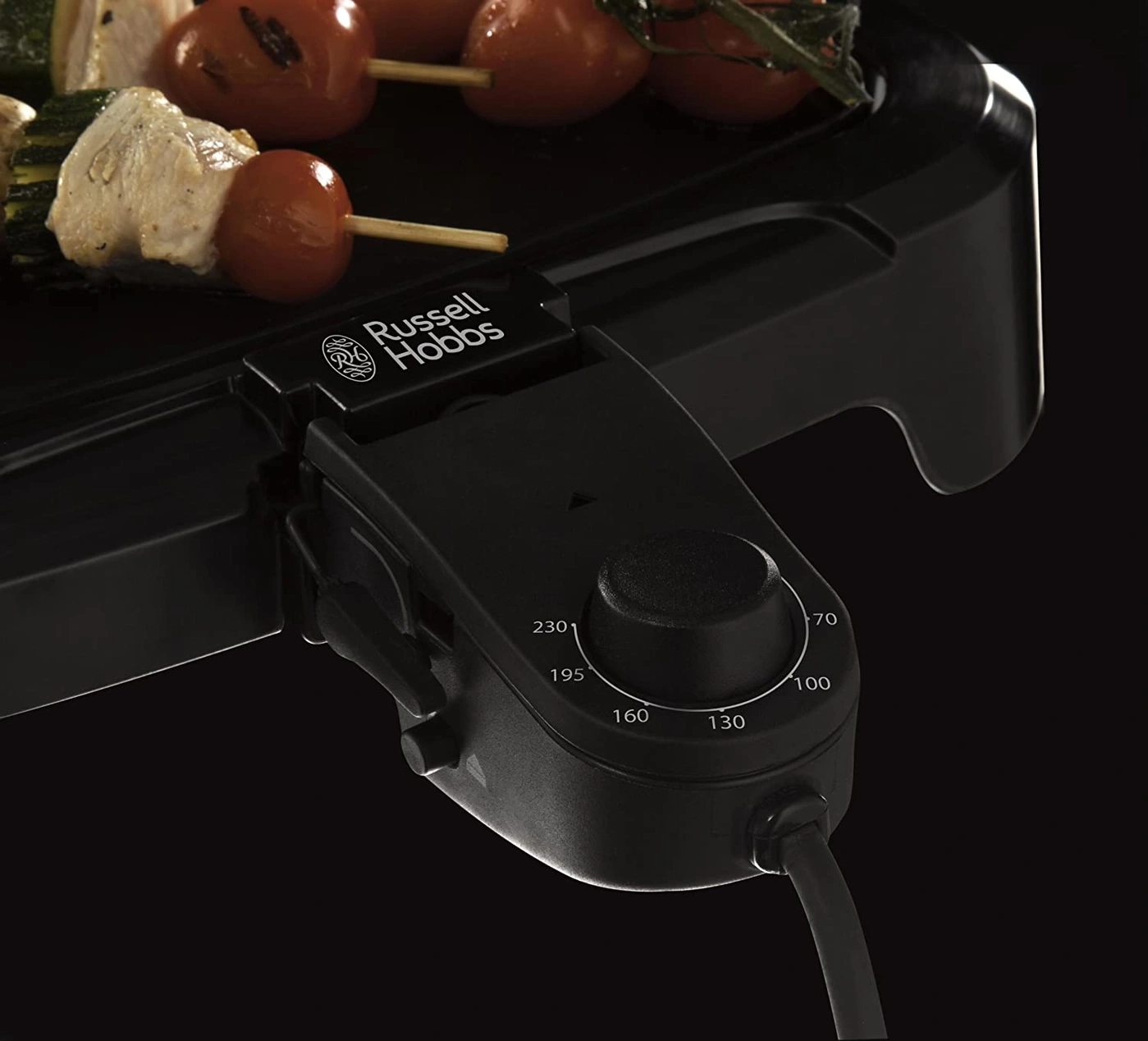 Nahaufnahme eines Russell Hobbs Grills mit Temperaturregler und Essen auf der Grillplatte