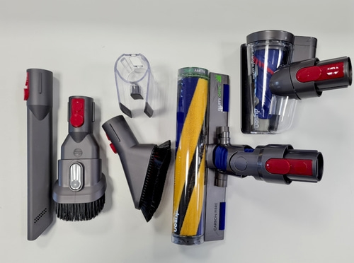 Staubsauger-Zubehörteile, verschiedene Aufsätze und Bürsten, grau und rot.