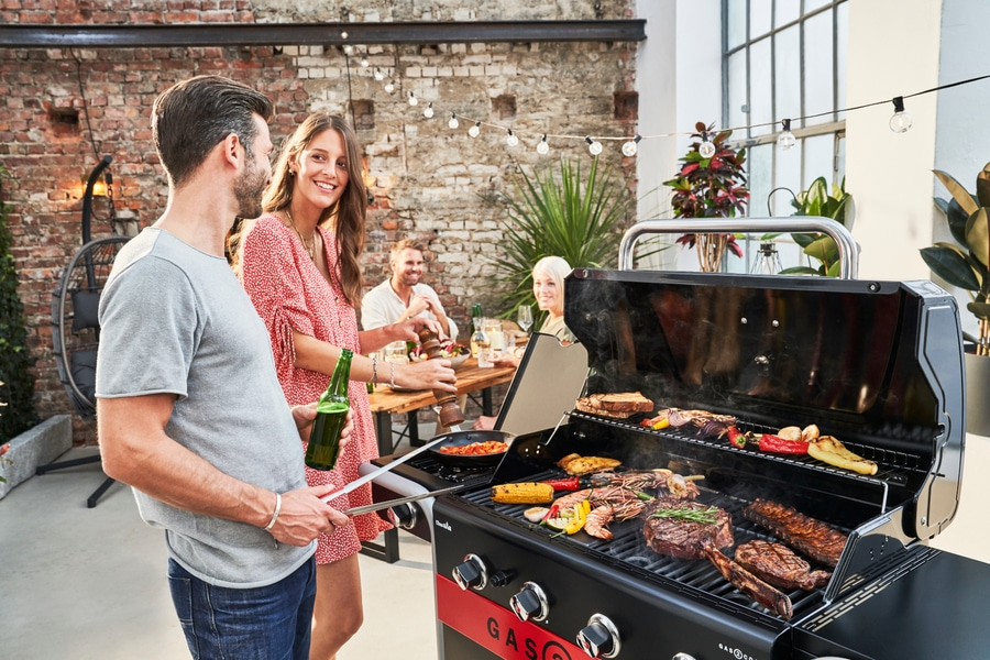 Grillparty im Freien mit Freunden und Familie, Essen und Trinken