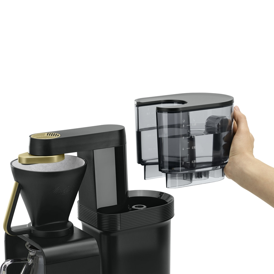 Kaffeemaschine mit abnehmbarem Wassertank, der von einer Hand gehalten wird, isoliert auf weißem Hintergrund.