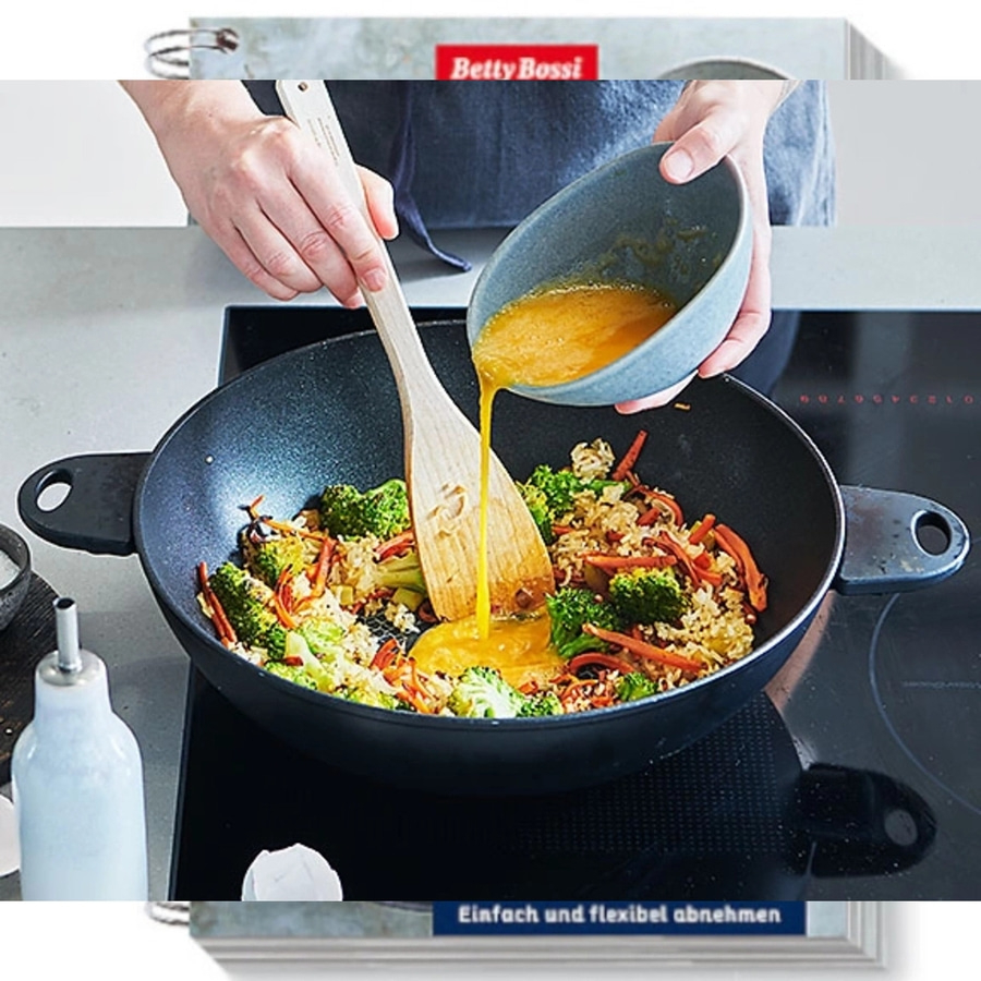 Person gießt Soße in eine Pfanne mit Gemüse. Kochen in der Küche.