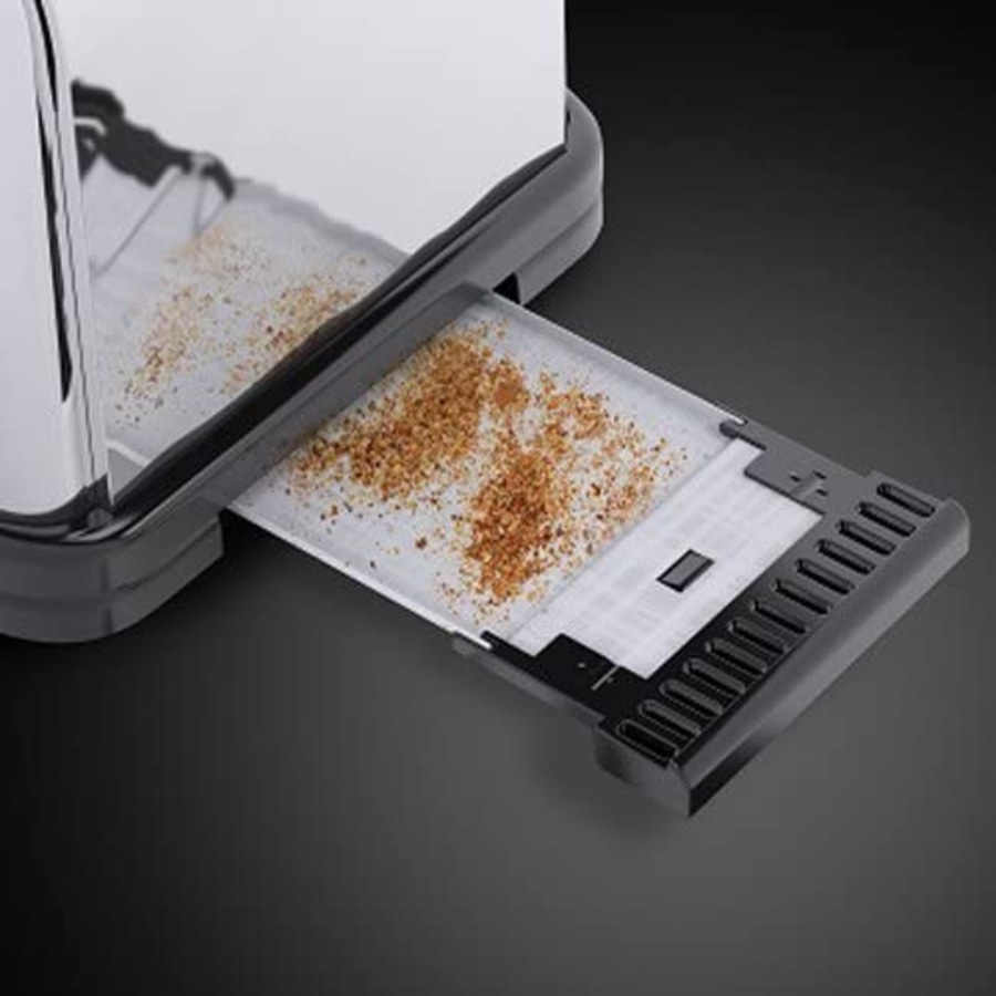 Nahaufnahme eines Toasters mit herausgezogener Krümelschublade, gefüllt mit Krümeln.