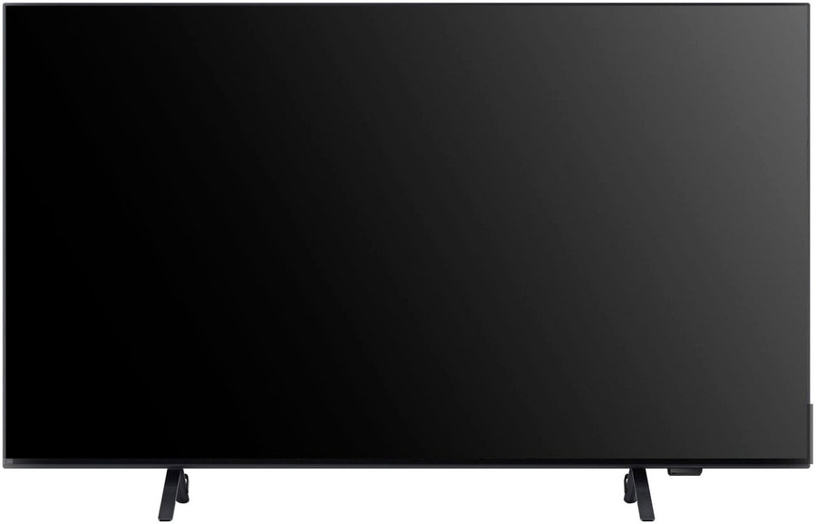 Schwarzer Fernseher mit zwei Füßen, der auf einer weißen Oberfläche steht.