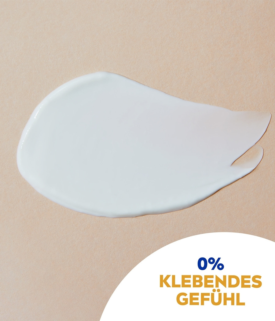 Weißer Creme-Klecks auf beigem Hintergrund mit Text: 0% Klebendes Gefühl