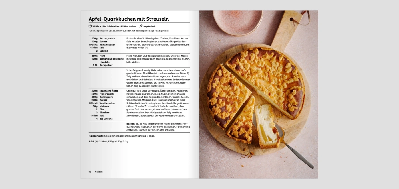 Apfel-Quarkkuchen mit Streuseln auf einem Holzbrett angeschnitten