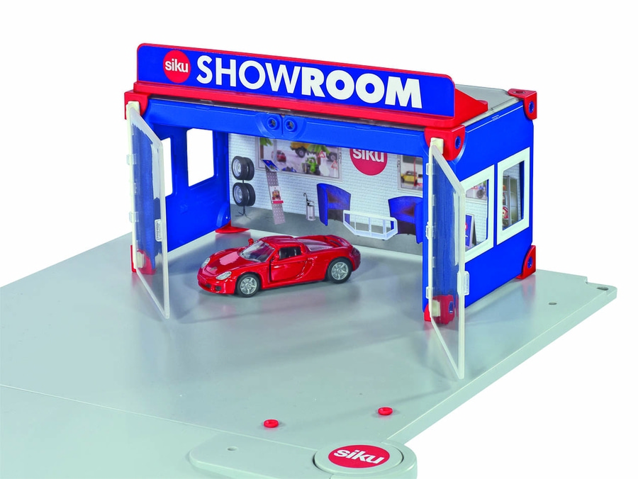 Spielzeug-Autohaus mit rotem Auto, blau-roter Fassade und Showroom-Schriftzug.