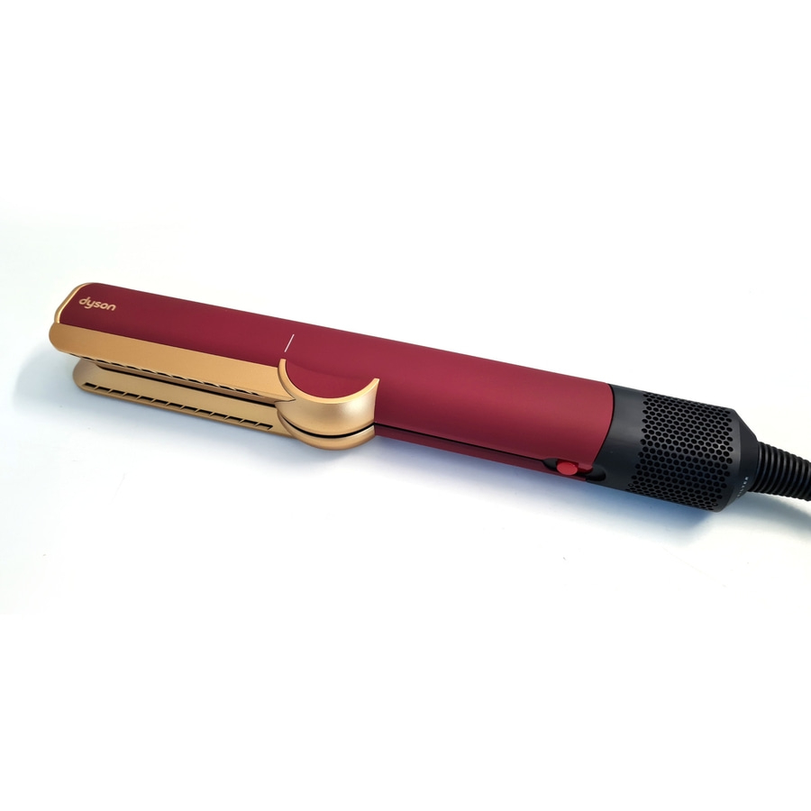 Ein rotes und goldenes Dyson Glätteisen mit schwarzem Griff und Lüftungsschlitzen