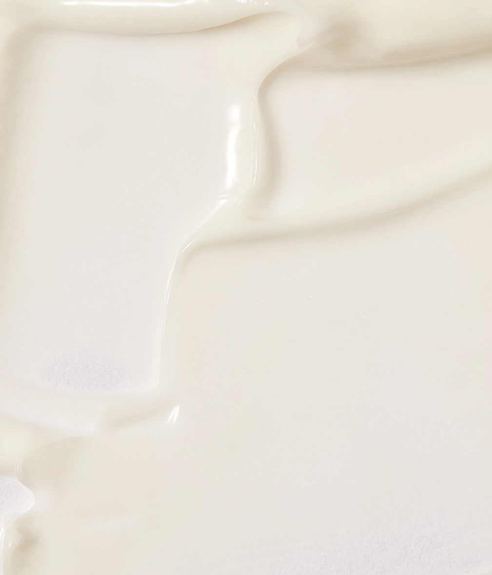 Creme-Textur, glatt und glänzend, in sanften Wellen auf weißem Hintergrund