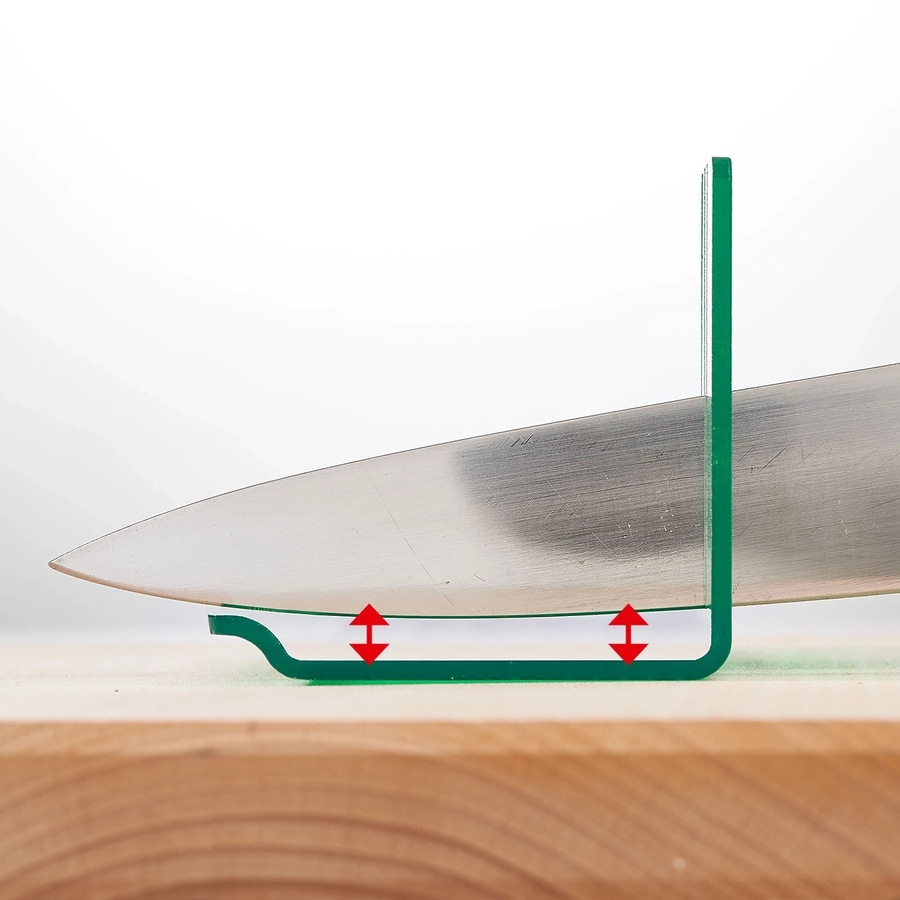 Messer auf Holzbrett mit grüner Messlehre zur Messung der Klingenhöhe