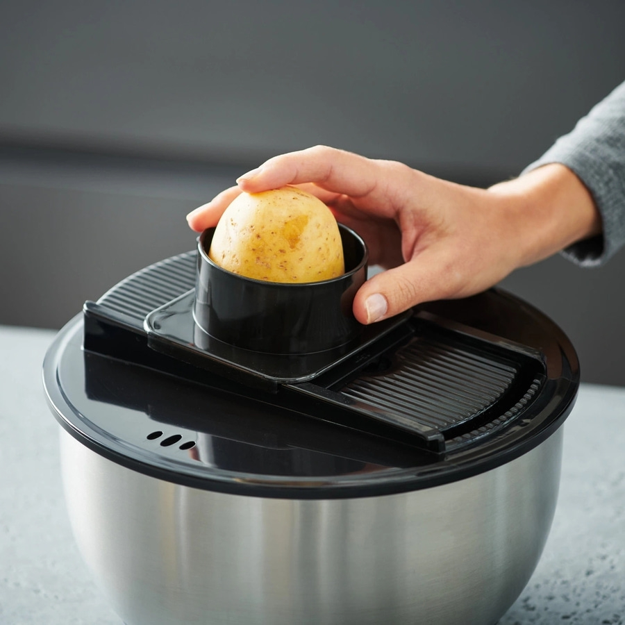 Kartoffelschneider mit Kartoffel und Hand, Nahaufnahme, Küche, Werkzeug, Gemüse