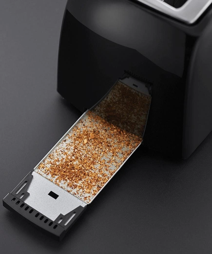Nahaufnahme eines Toasters mit herausgezogener Krümelschublade, gefüllt mit Krümeln.