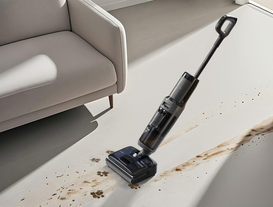 Ein Nass-/Trockensauger reinigt einen schmutzigen Boden vor einem Sofa.