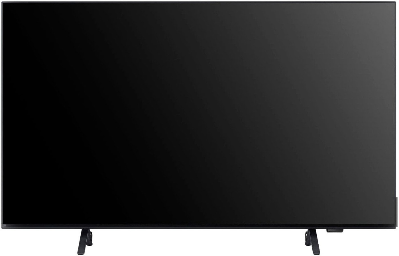 Schwarzer Fernseher mit zwei Füßen, der auf einer weißen Oberfläche steht.