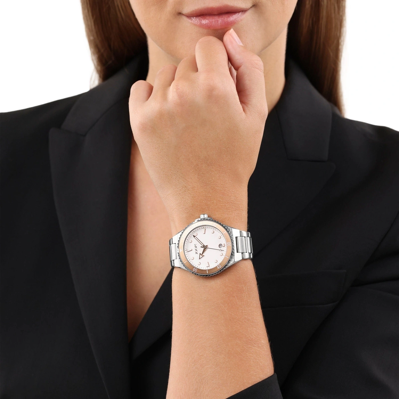 Nahaufnahme einer Frau mit schwarzem Blazer und einer eleganten Uhr am Handgelenk