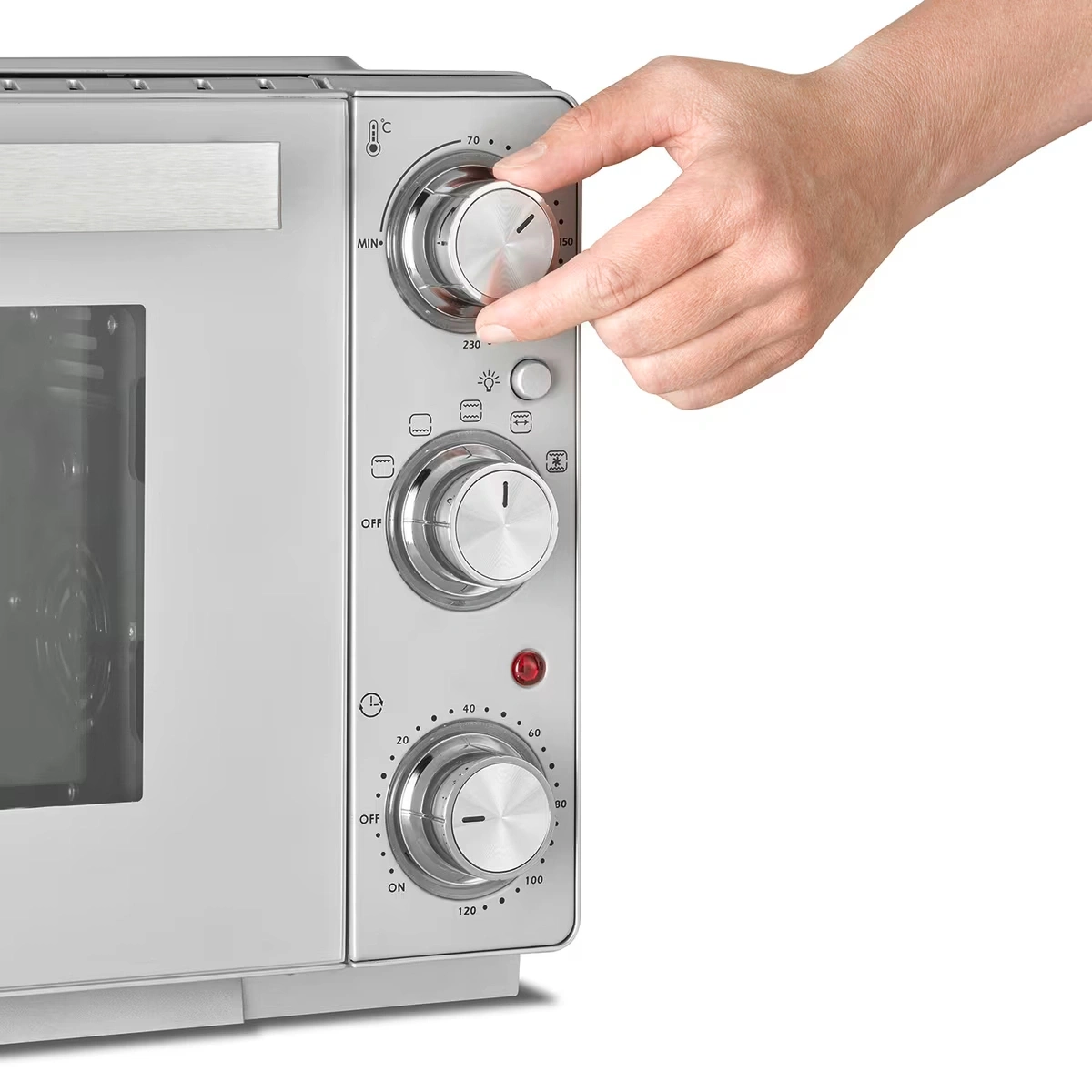 Hand dreht Regler an einem silbernen Ofen