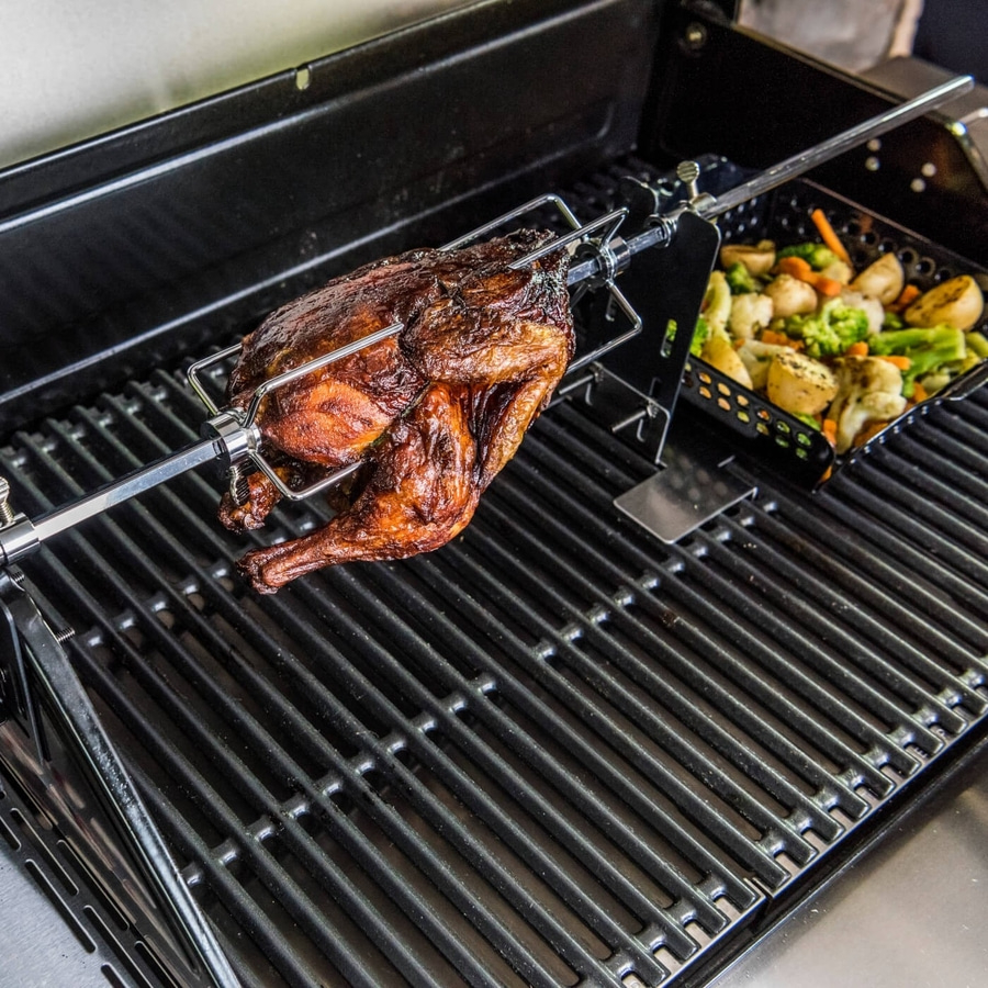 Gebratenes Huhn auf einem Grill mit Gemüse in einer Schale