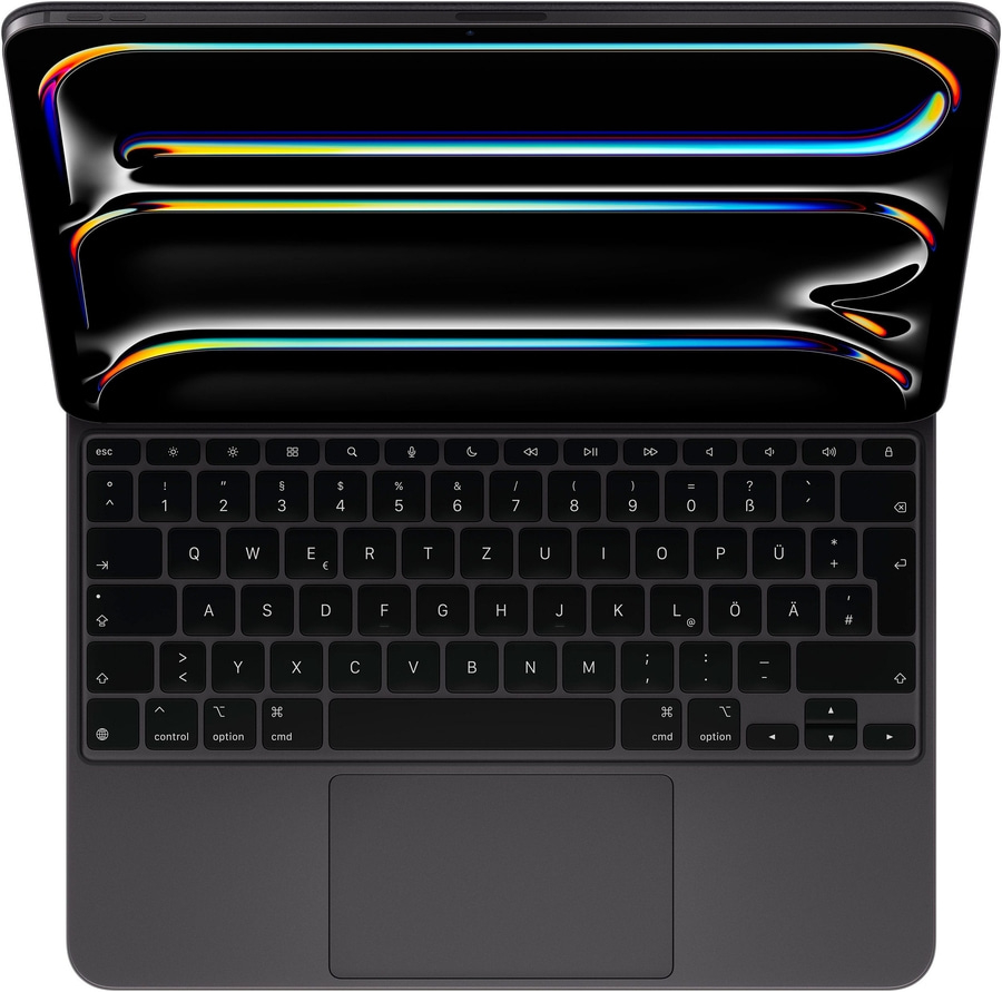 Schwarzes MacBook mit beleuchteter Tastatur und Touchpad, das auf einem Tisch liegt.