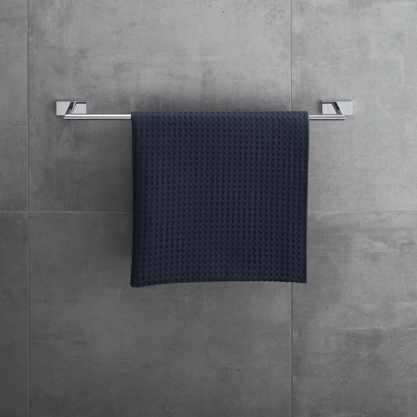 Handtuch an einer Halterung vor einer grauen Wand. Badezimmer-Dekoration.